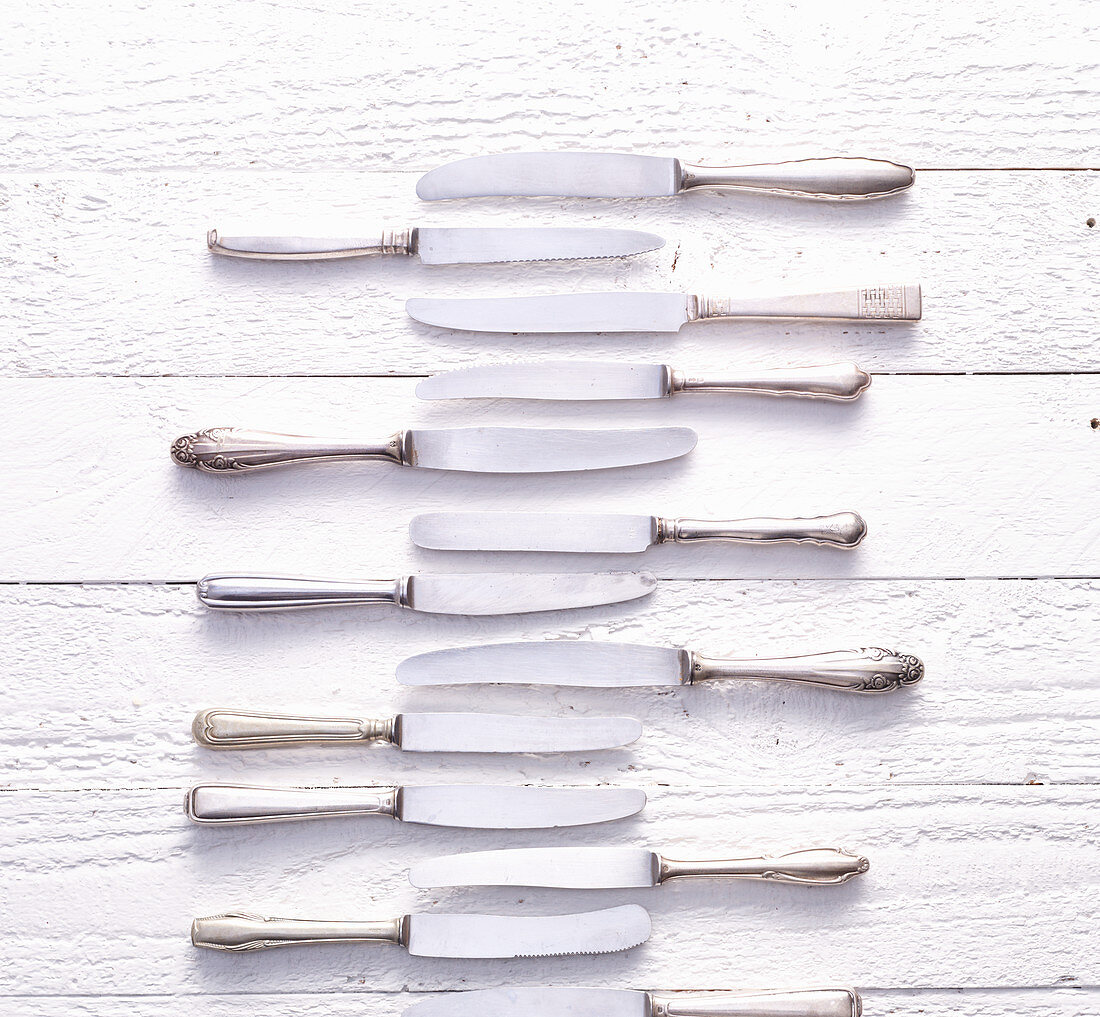 Vintage knives on a white wooden background