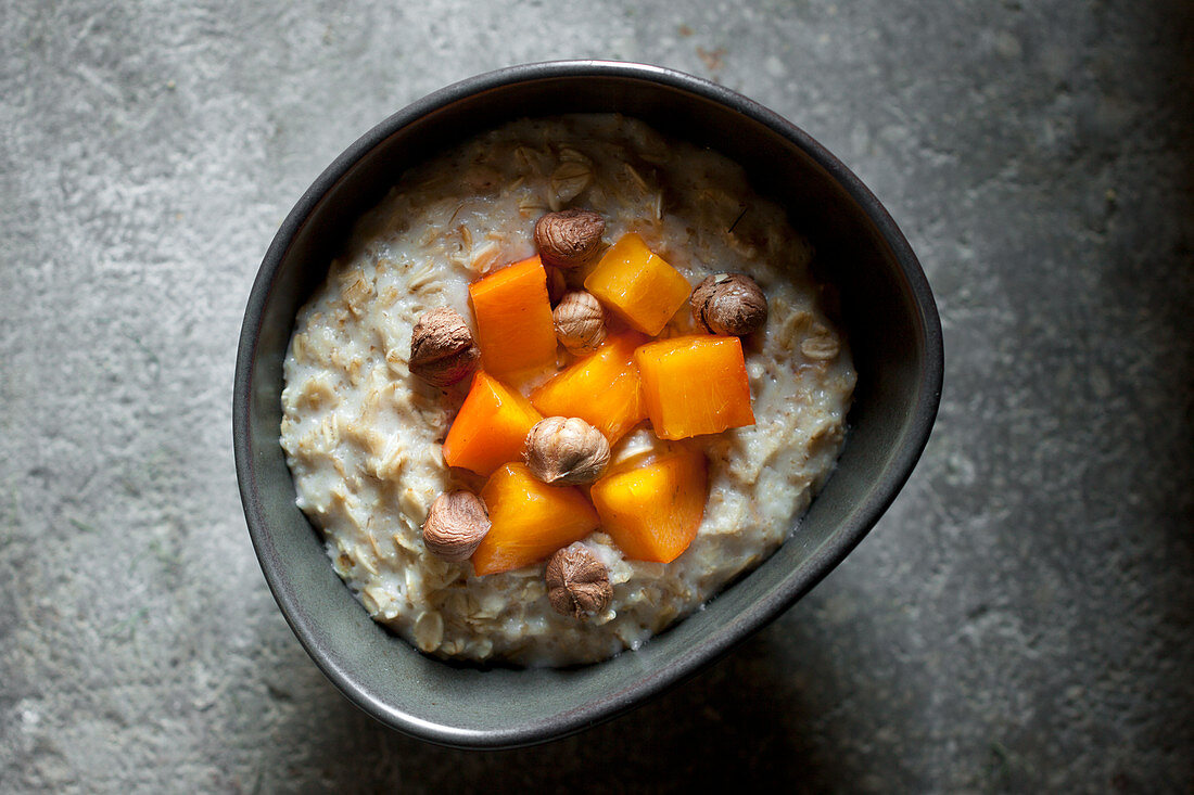 Vollkorn-Porridge mit Kaki und Haselnüssen