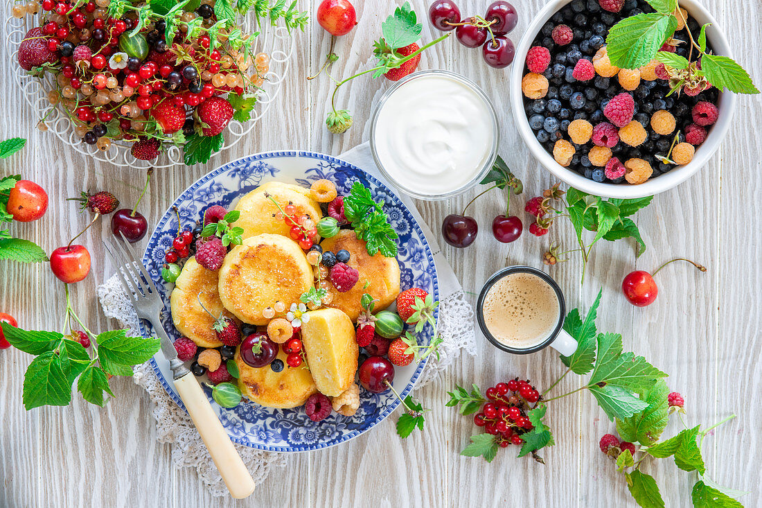 Syrniki (Hüttenkäsepfannkuchen) mit frischen Beeren