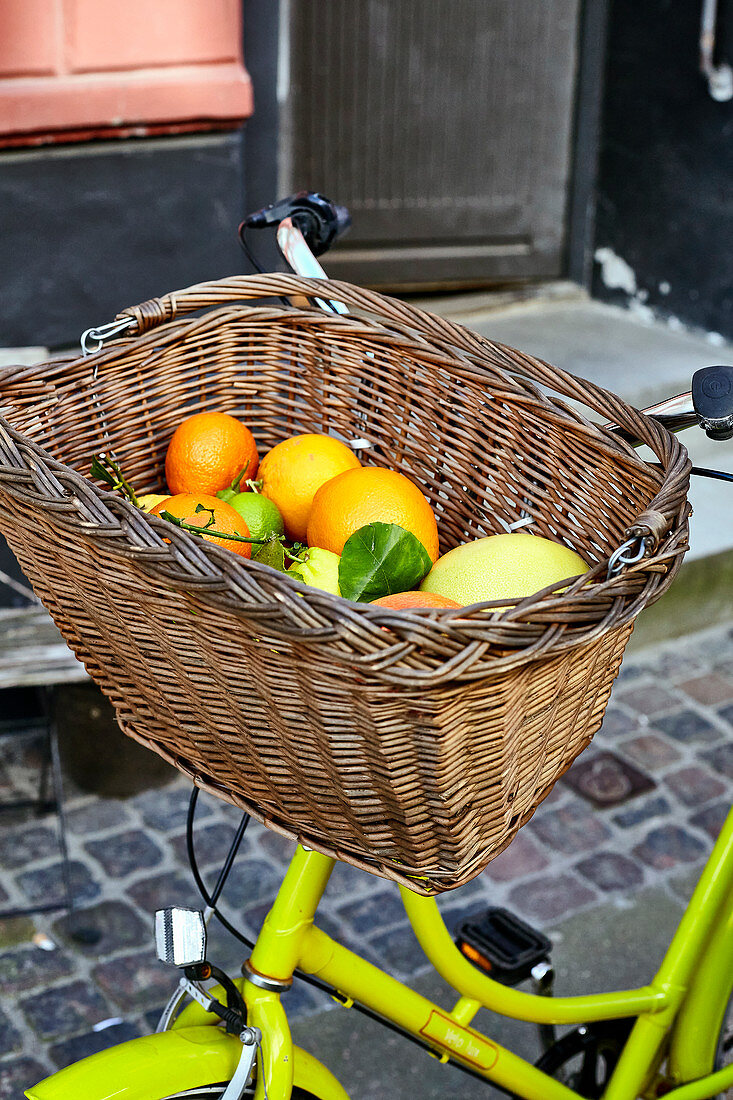 Various citrus fruits in a bicycle basket