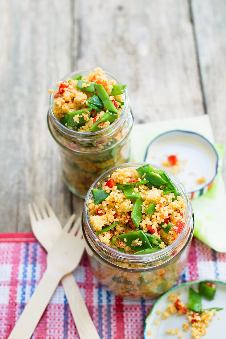 Vegan couscous salad with bell pepper and sugar snap peas in a glass jar