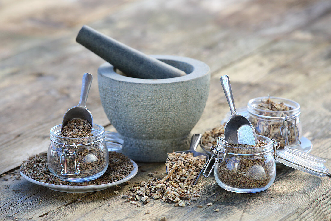 Various dried tea herbs with a mortar