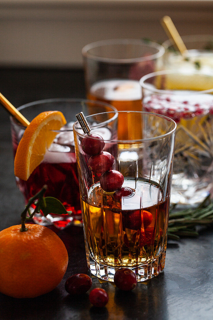 Verschiedene alkoholische Drinks mit Früchten und Kräutern