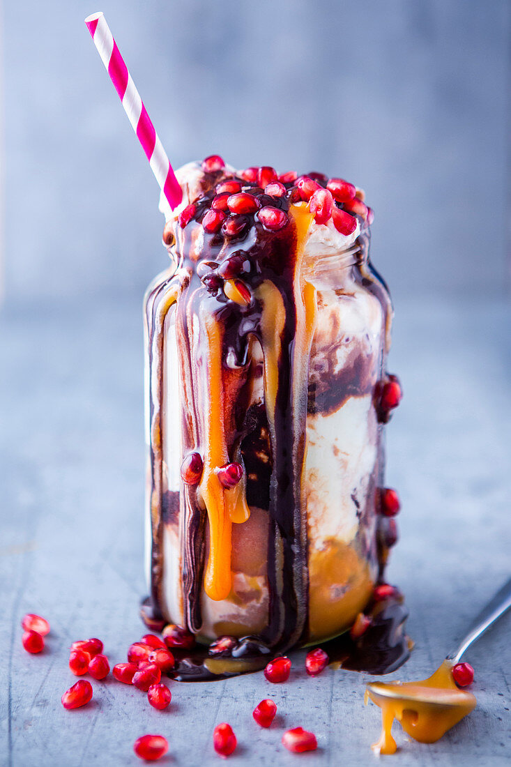 Freak shake with ice cream, caramel sauce and pomegranate seeds