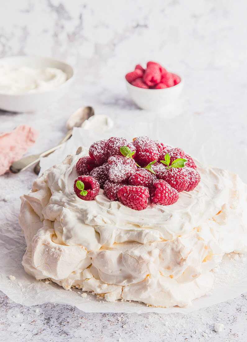 Pavlova dessert, served with mascarpone cream and fresh rasberries