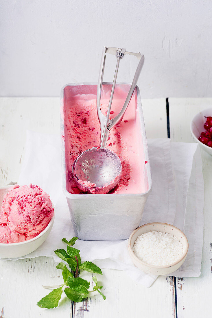 Pink ice cream with raspberries, coconut, mint and red currants