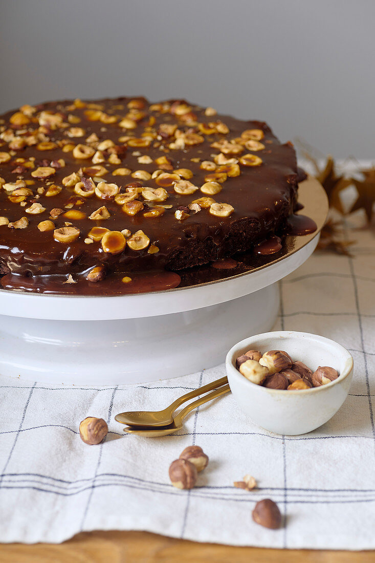 Vegan brownie cake with hazelnuts and salted caramel n white cakestand