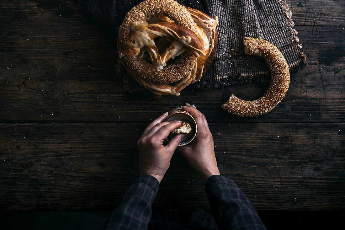 Käsebrezeln und Sesamringe mit Dip auf rustikalem Holztisch