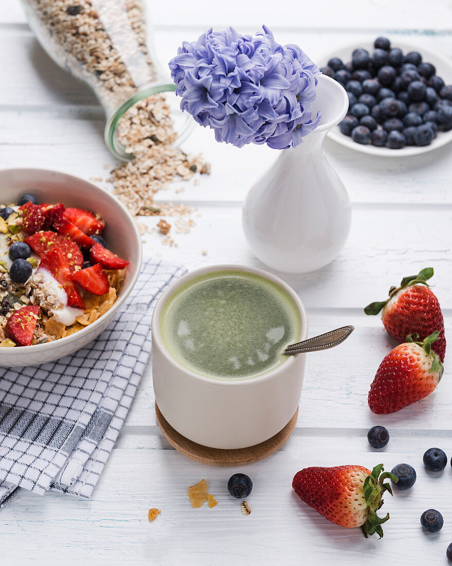 Matcha tea and muesli with almond yogurt and fresh berries