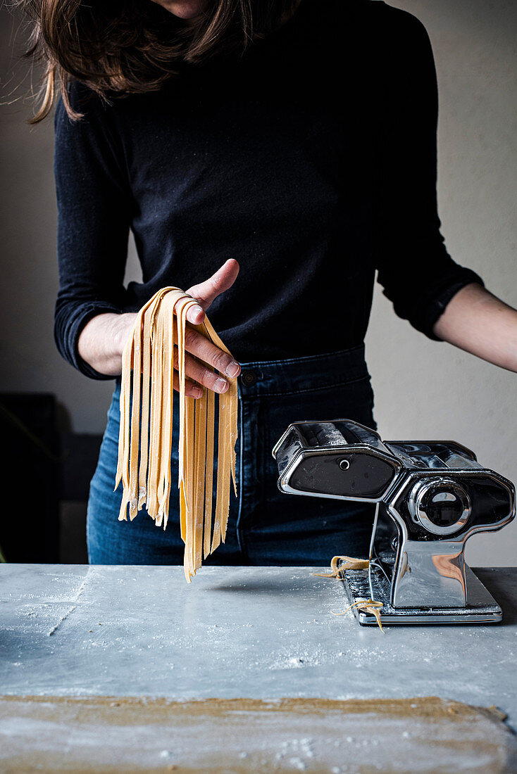 Woman Making Fresh Pasta in a kitchen