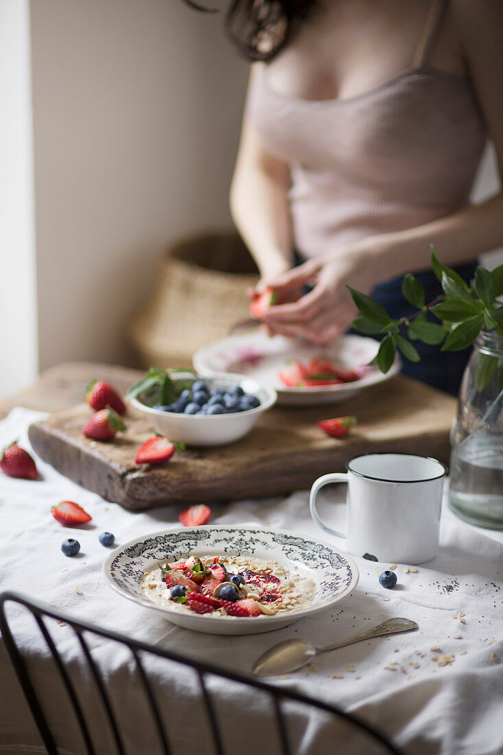 Woman cutting strawberries on a breakfast table