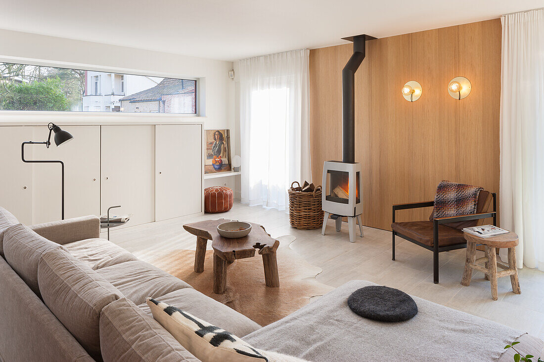 Living room with wood-burning stove, wooden elements and neutral colors