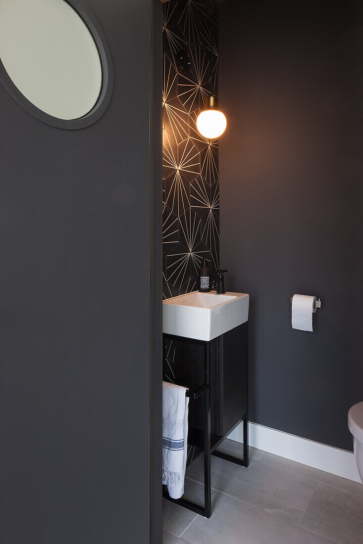 Dark guest bath with geometric wall pattern