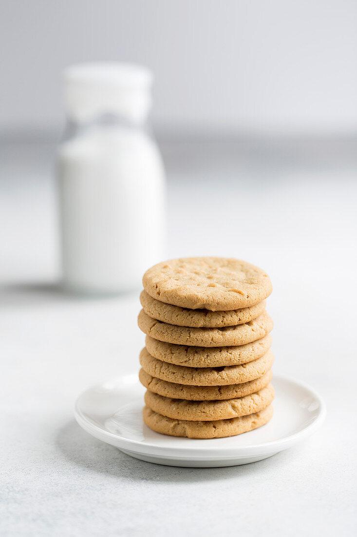 Peanut butter cookies stacked on a small plate.