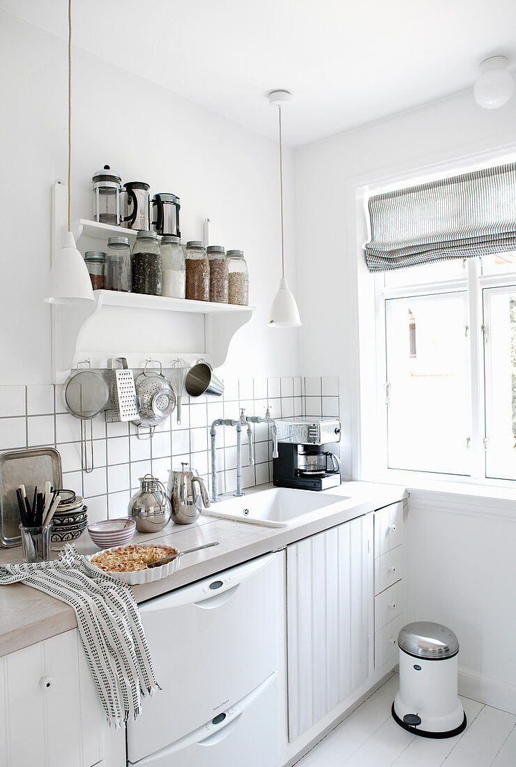 Groceries on shelves in white kitchen