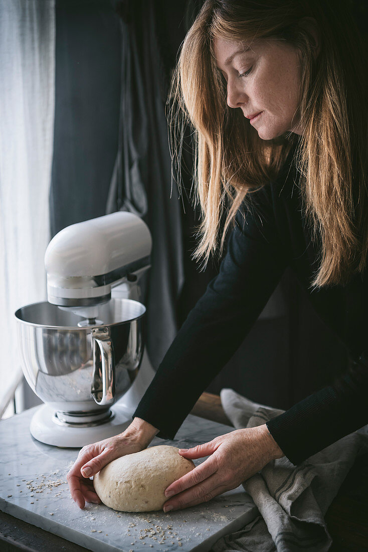 A woman preparing a loaf of bread