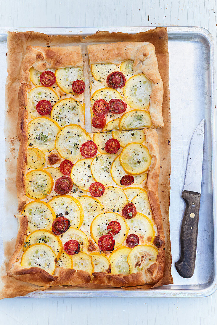 Tomato zucchini tart on a baking sheet