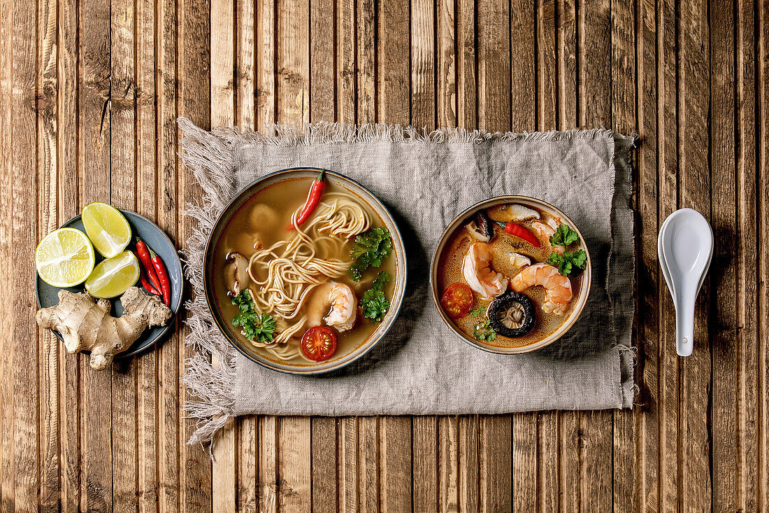 Variety of asian soups: Traditional spicy Thai tom yum kung and noodles soup with shiitake mushrooms, prawns