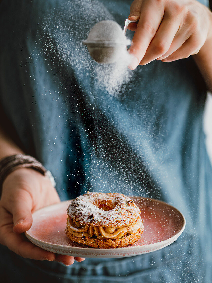 Choux Craquelin wird mit Puderzucker bestaubt