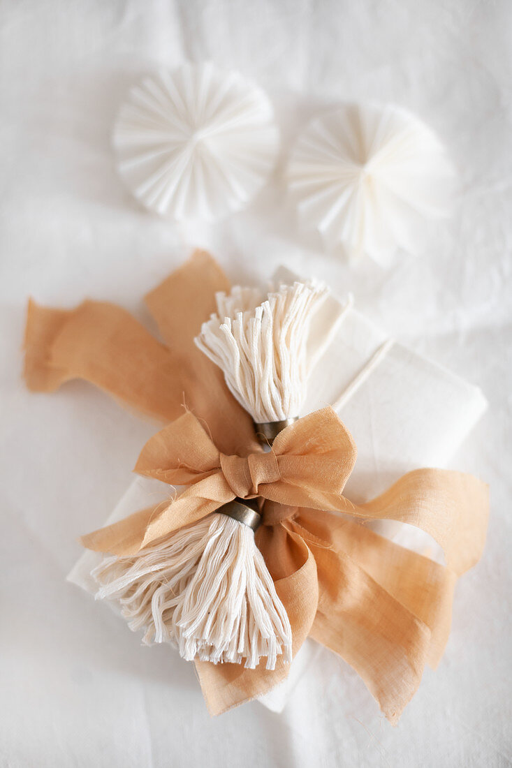 Wrapped gift decorated with handmade tassels and fabric ribbon