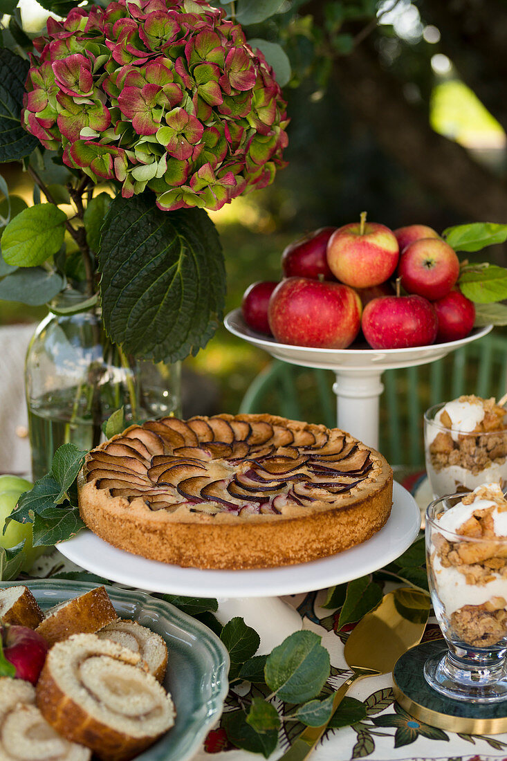 Buffet mit Apfelkuchen, Apfel-Biskuitrolle und Apfeldessert im Glas