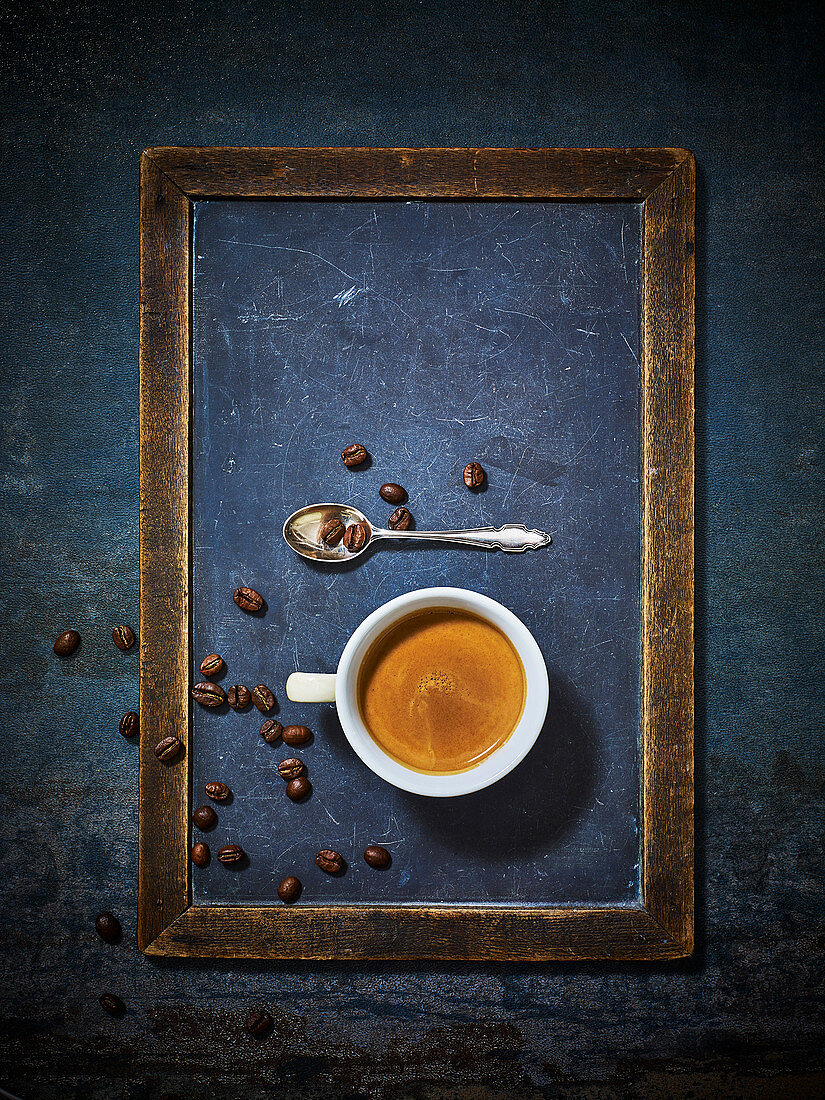 Ein Tasse Espresso mit Kaffeebohnen und Löffel