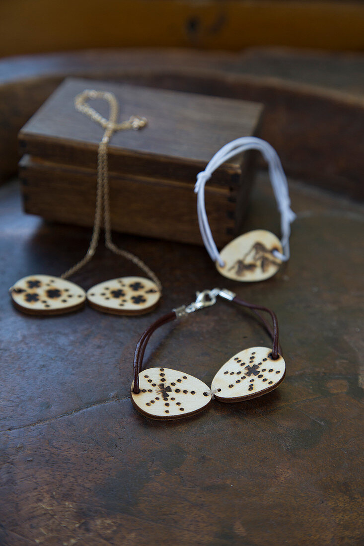 Necklace and bracelets with pendants made from discs of wood decorated with poker work