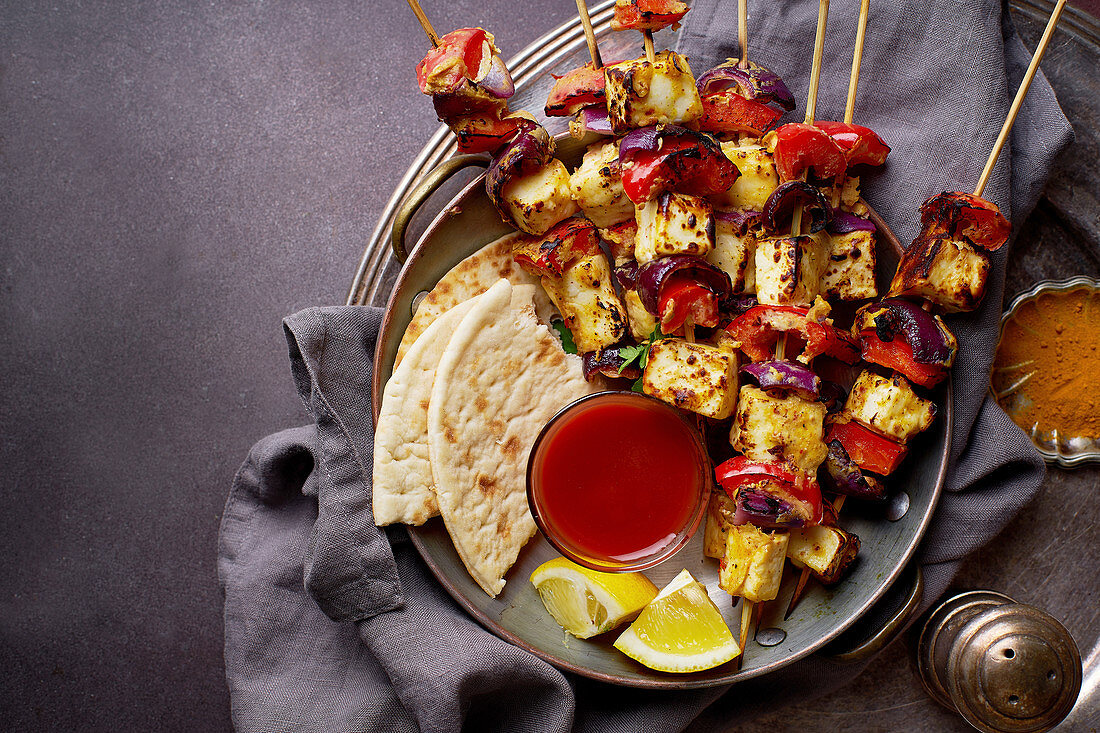 Grilled onion and pepper paneer skewers with, flatbread and chili sauce