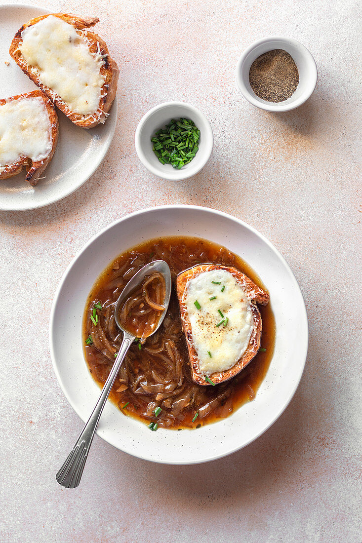 A bowl of French onion soup on the table.