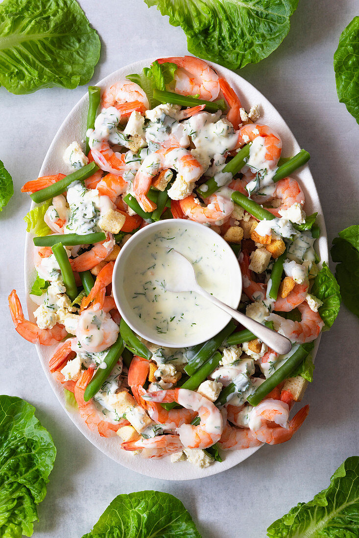 A platter of prawns and green bean salad with dill dressing.
