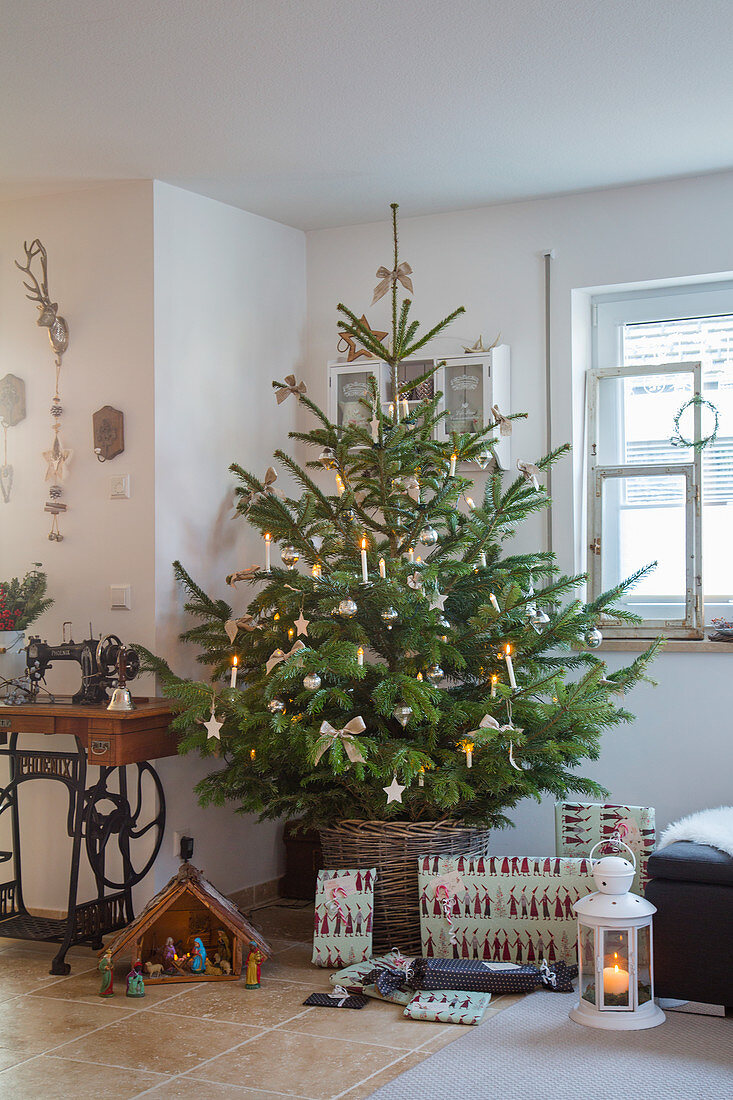 Geschenke und Krippe vorm Weihnachtsbaum im Korb