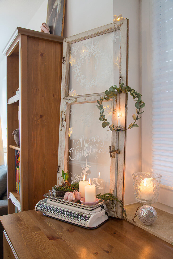 Christmas greeting painted on old window decorated with fairy lights