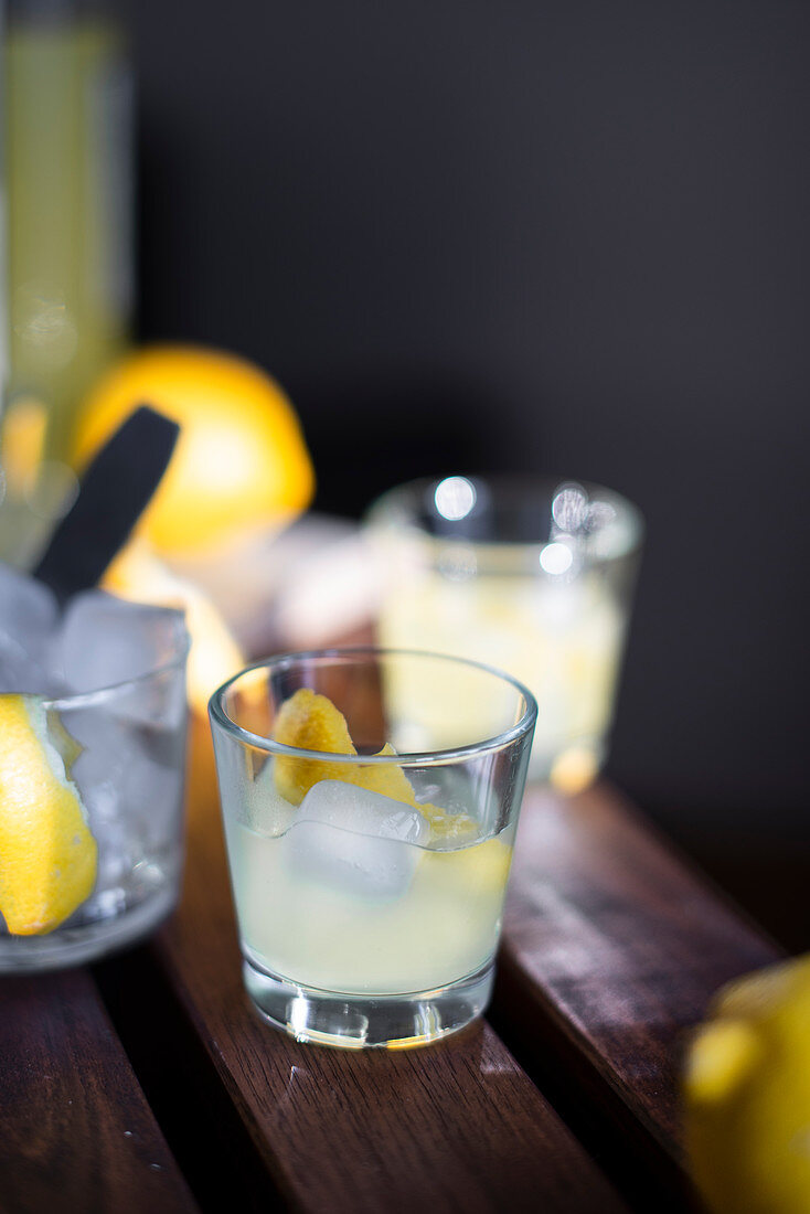 Limoncello with ice cubes and fresh lemon peel