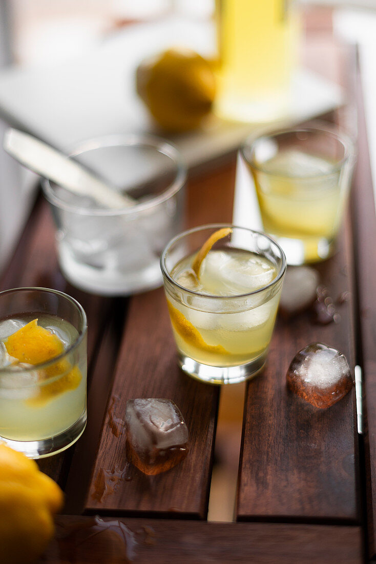 Limoncello with ice cubes and fresh lemon peel