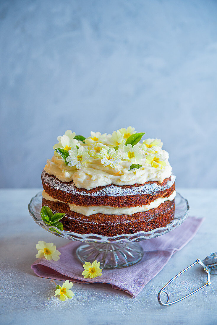 Carrot cake with cream cheese icing and edible flowers