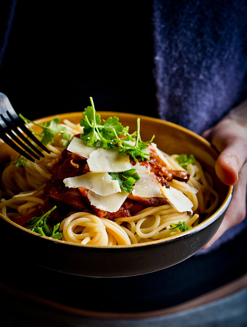 Man holding spaghetti with oyster mushroom tomato sauce