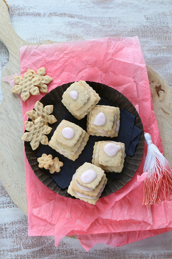 Gluten-free layered biscuits with pink icing and waffle biscuits on pink tissue paper