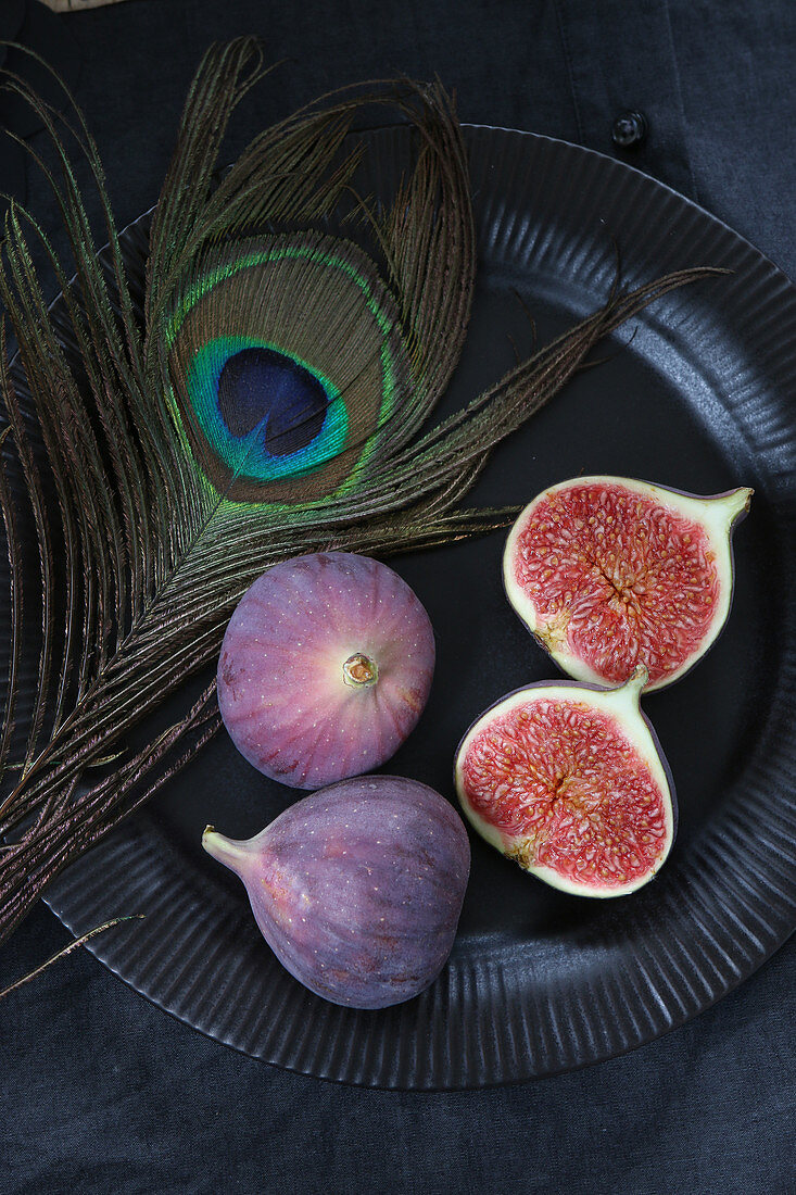 Fresh figs, whole and halved, on a black plate