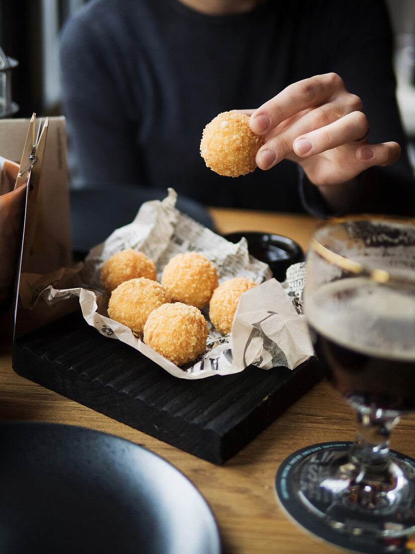 Crop female holding delicious cheese ball with mozzarella filling