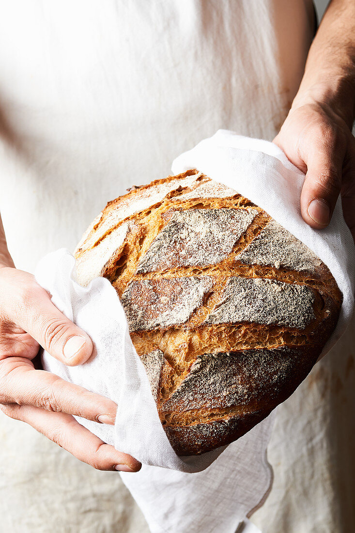 Baker holds freshly baked bread