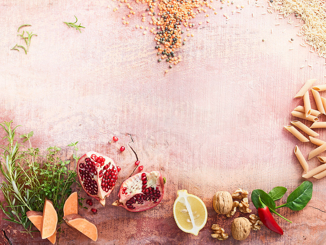 An arrangement of penne pasta, walnuts, sweet potatoes, pomegranate and rice