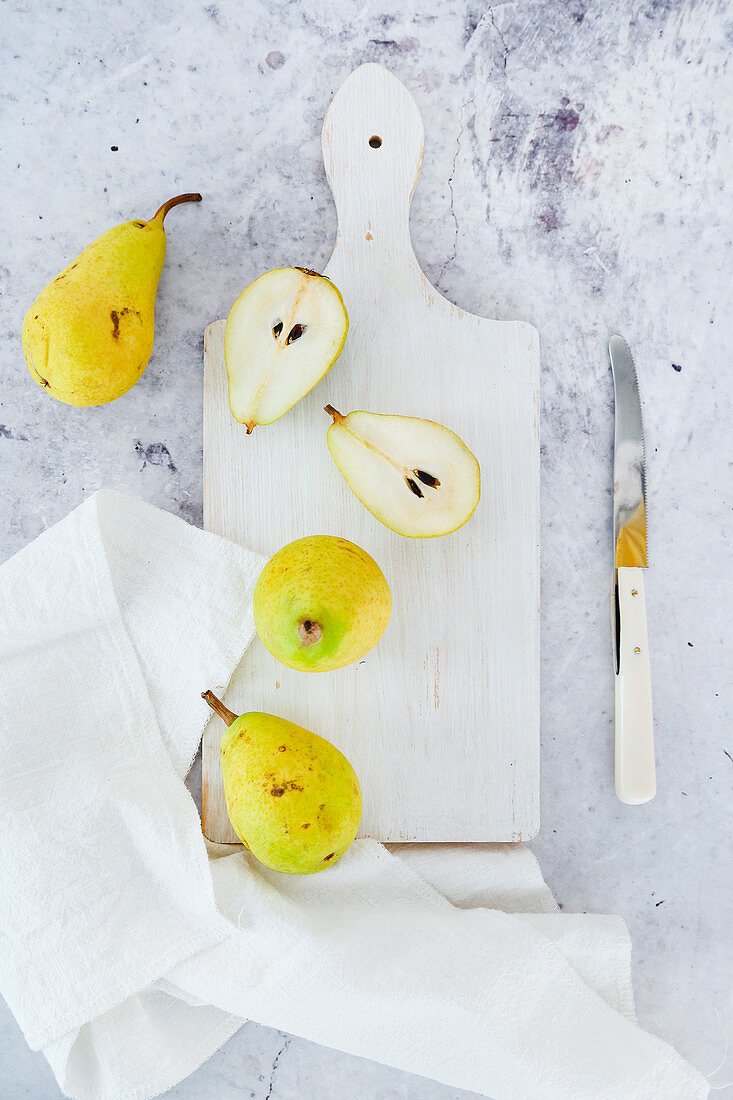 Small pears on white cutting board