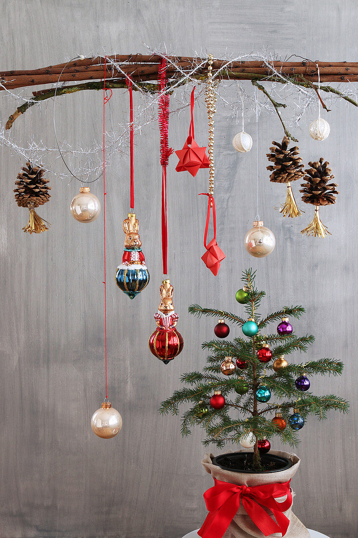 Anhänger und Zapfen mit Quasten am Zweig überm Christbaum