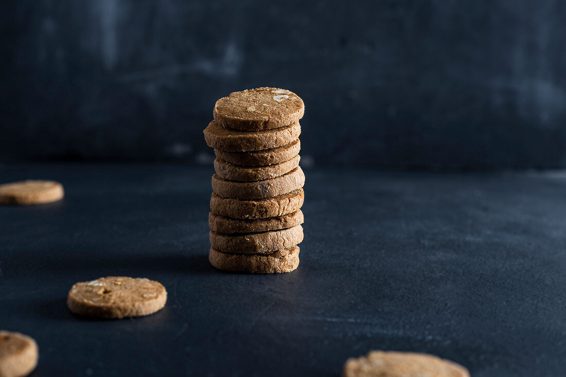 A stack of spelt cookies with almonds against a dark background