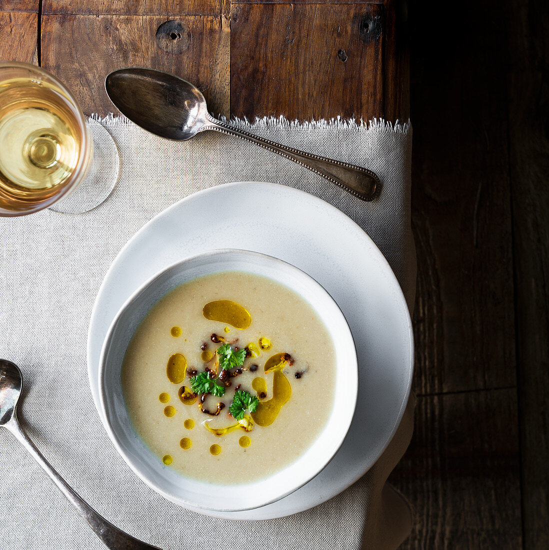 Cauliflower soup with garnish of fried cauliflower florets, olive oil and parsley