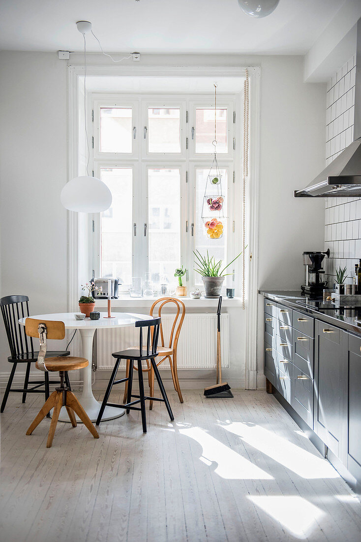 Various chairs around round designer table in kitchen-dining room