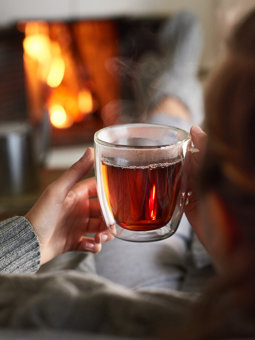 Enjoying a hot cup of tea in front of a blazing fire