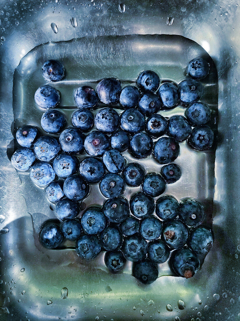 Water Splashing Over Fresh Blueberries in a Spoon Colander