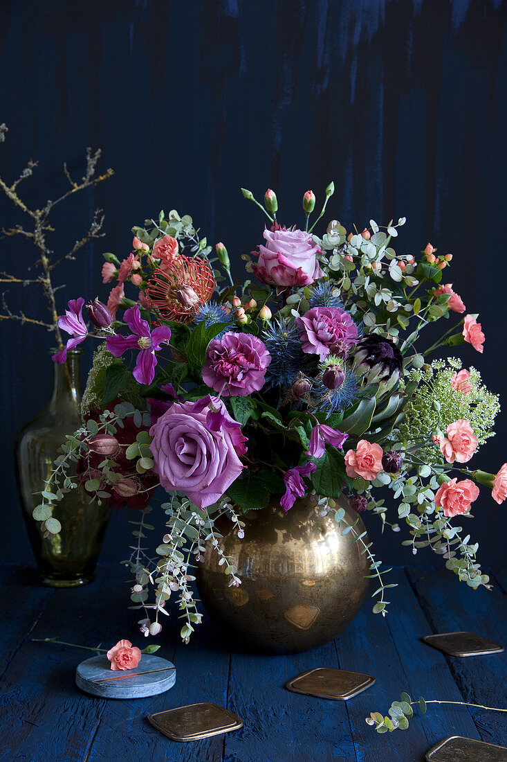 Vintage-style bouquet of roses, pinks, eucalyptus, clematis, proteas, Banksia, St. John's wort, sea holly and wild carrot