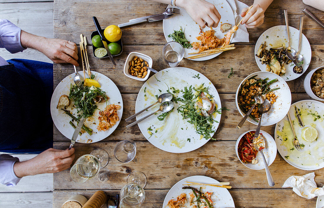 A table laid for a barbecue party with some plates already cleaned